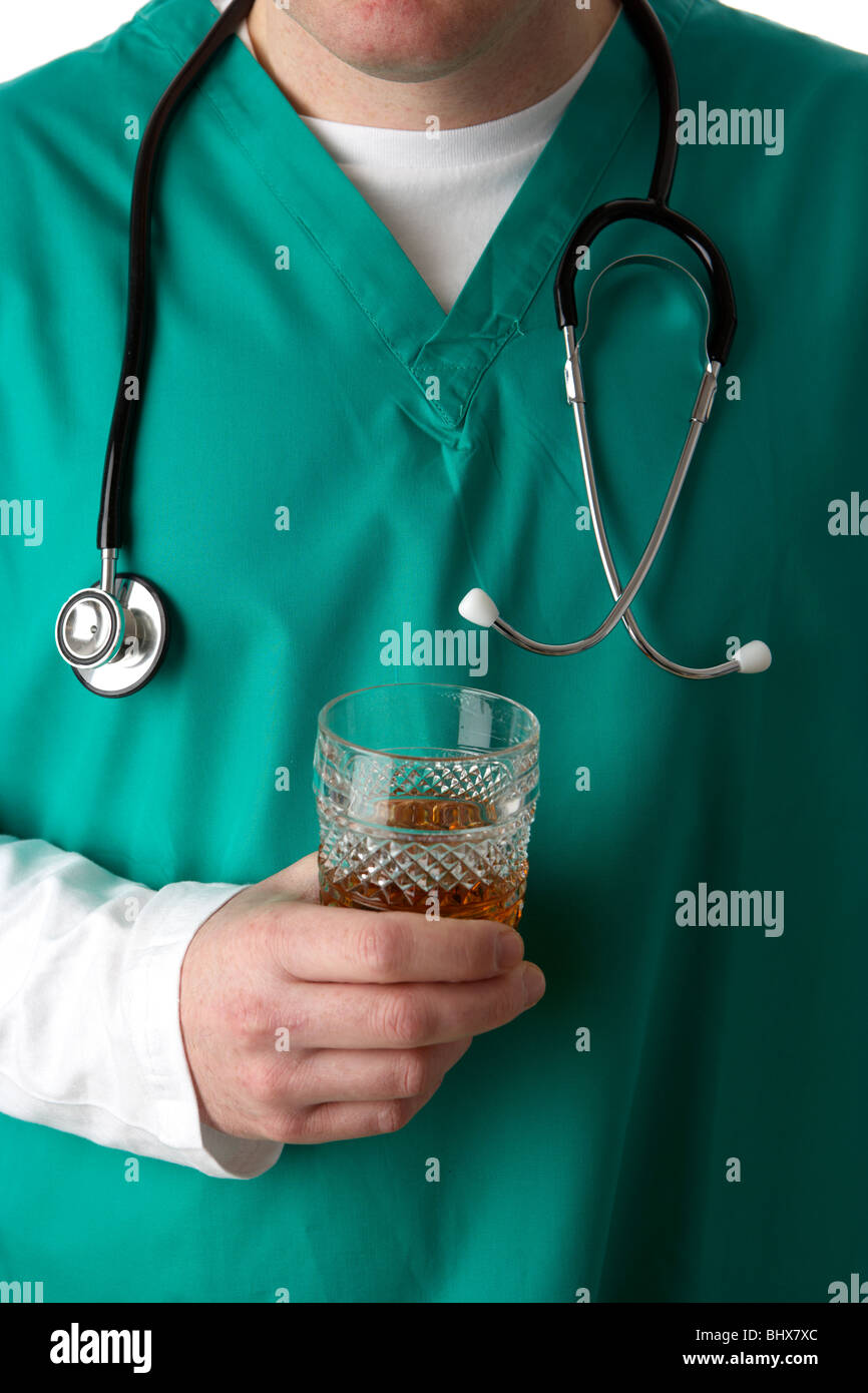 Uomo che indossa medical scrubs e stetoscopio tenendo un bicchiere di liquori alcol Foto Stock