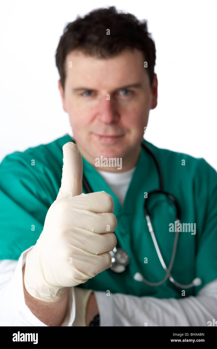 Uomo che indossa medical scrubs e uno stetoscopio che mostra Thumbs up gesto di successo Foto Stock