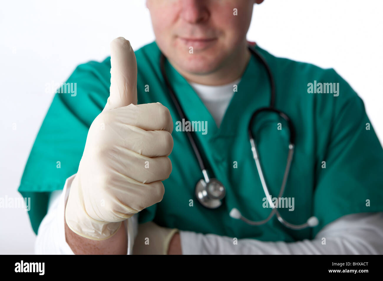 Uomo che indossa medical scrubs e uno stetoscopio che mostra Thumbs up gesto di successo Foto Stock