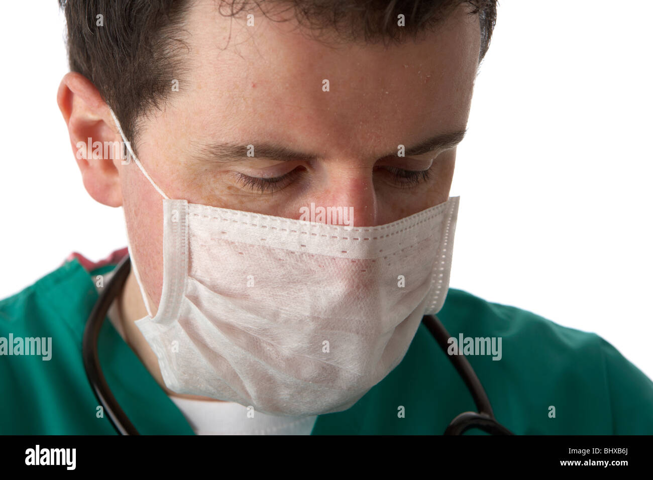 Uomo che indossa medical scrubs e uno stetoscopio che indossa la maschera per il viso Foto Stock