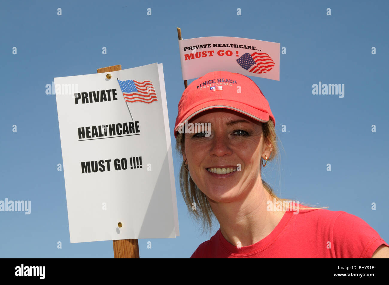 Assistenza sanitaria privata negli Stati Uniti devono andare manifestante femmina indossando un cappello rosso con bandiera Foto Stock