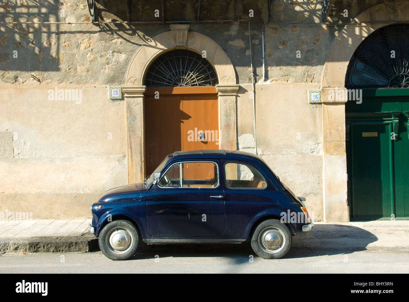Fiat 500 auto parcheggiate fuori dall'ingresso al tradizionale edificio italiano in Sicilia Foto Stock