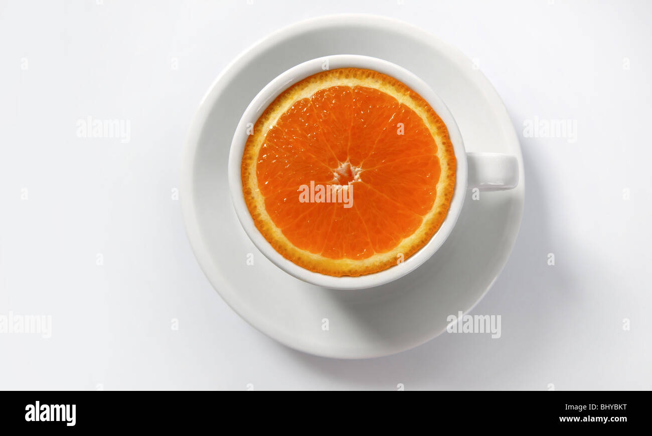 Fetta di arancia in una tazza di caffè, alimenti naturali invece la metafora di caffeina Foto Stock