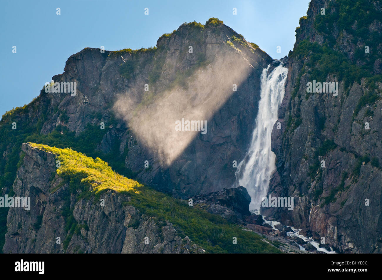 Terranova, Western Brook Pond, Parco Nazionale Gros Morne, raggi solari e cascata cascading a rocce al di sotto di Foto Stock