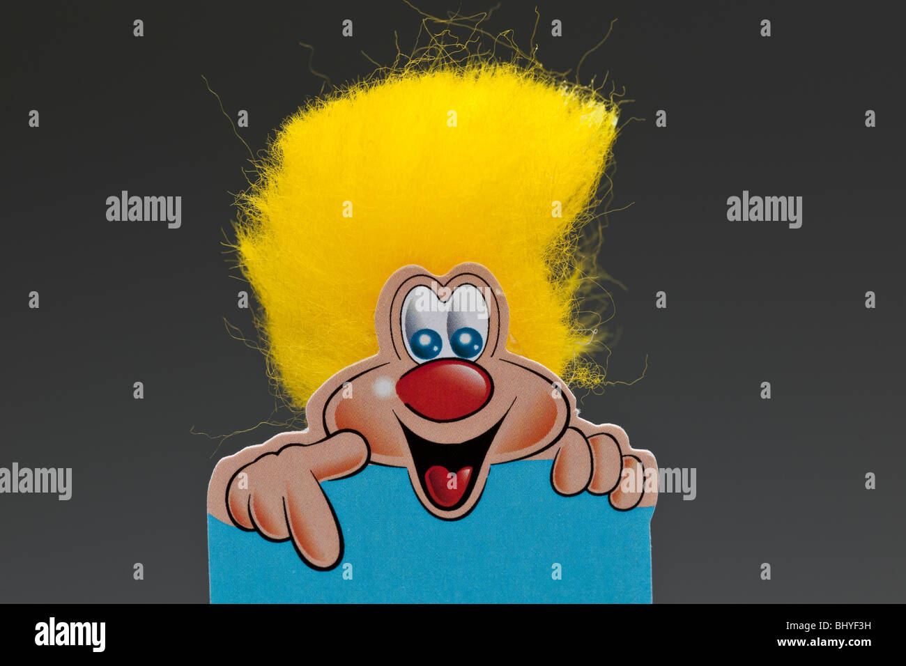 Giallo sorridente dai capelli cespuglioso personaggio dei fumetti rivolto verso il basso Foto Stock