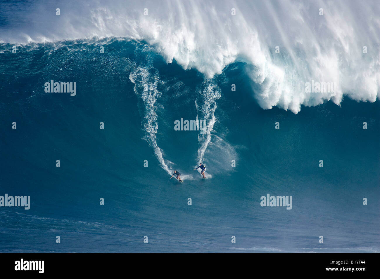 Due surfisti goccia giù un onda gigante a ganasce, Peahi, Maui. Foto Stock