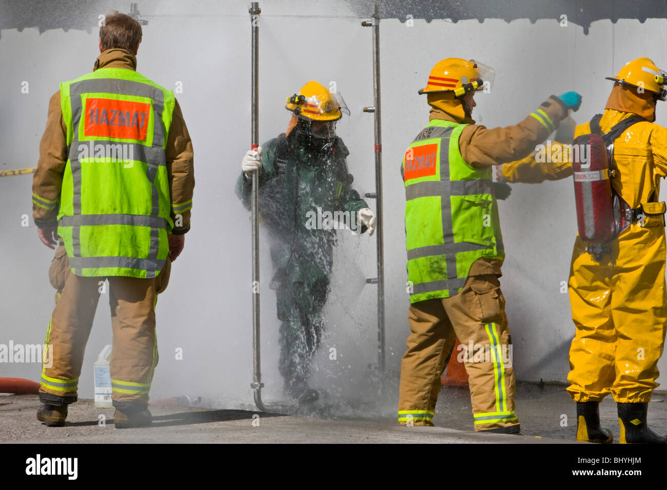 Fireman lavi giù dopo il trattamento con materiale pericoloso incidente Foto Stock