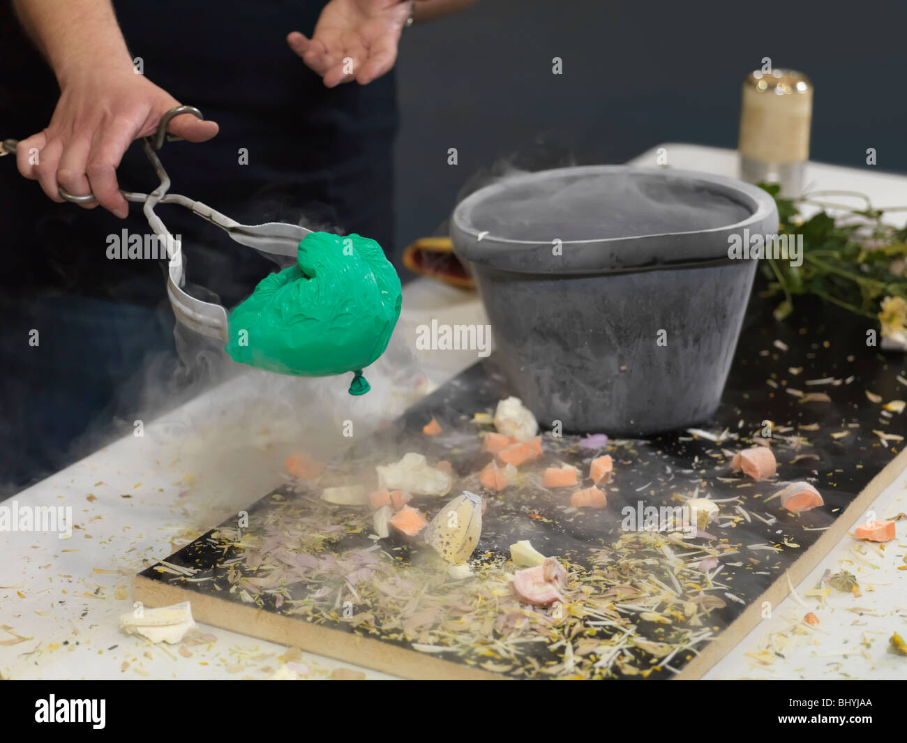 Persona tenendo un ristretto pallone aerostatico fuori da un contenitore con azoto liquido Foto Stock