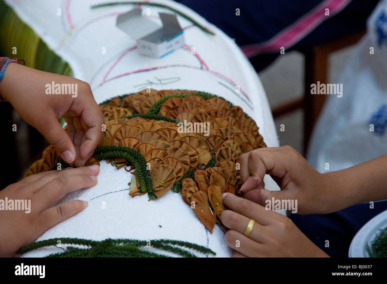 I bambini progetto d'arte. Molte mani lavorando sul Festival dei Fiori per Decorazione di un galleggiante per la trentaquattresima Chiang Mai Festival dei Fiori 2010, Thailandia del Nord Foto Stock