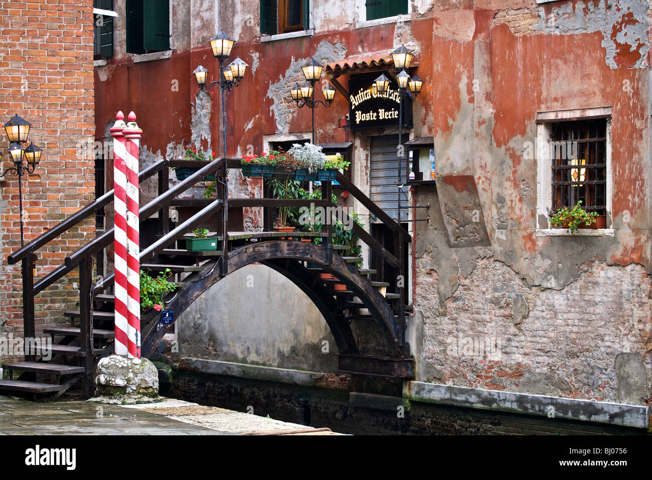 Un piccolo ponte su un canale stretto per un ristorante a Venezia, Veneto, Italia Foto Stock