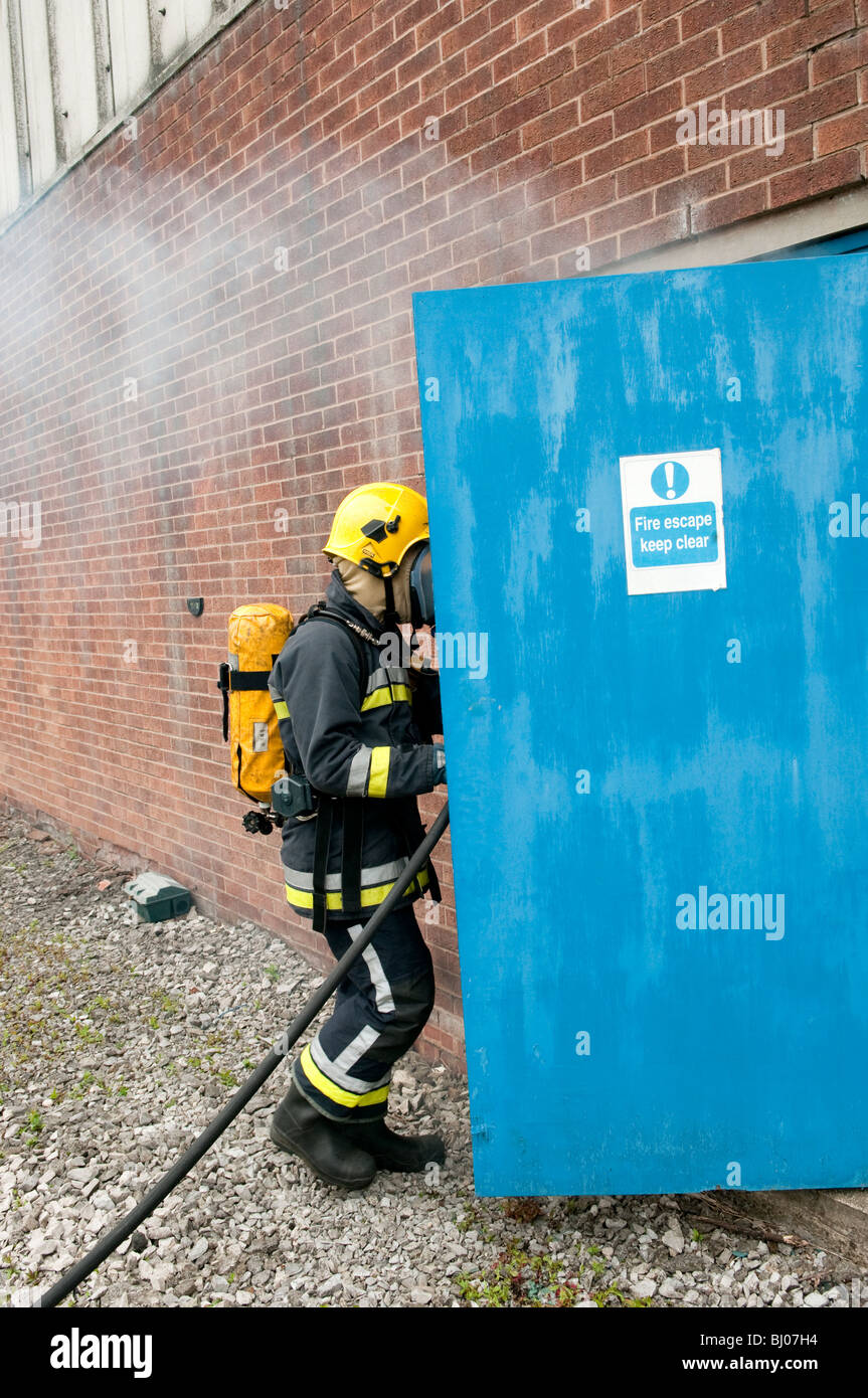 Vigili del fuoco di entrare attraverso la fabbrica porta antincendio Foto Stock