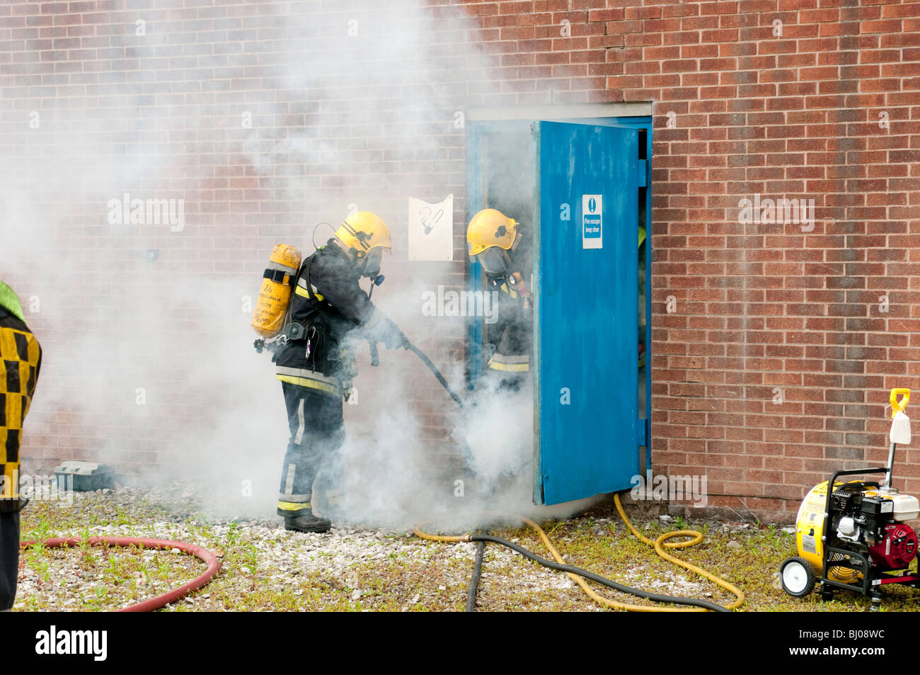 I vigili del fuoco e del fumo dalla fabbrica porta antincendio Foto Stock