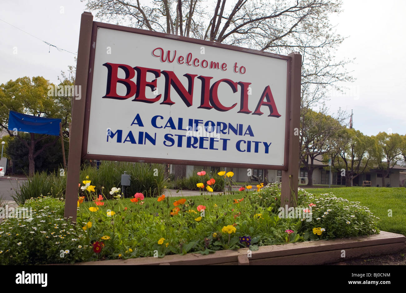 Town benvenuto firmare per Benicia, California. fiori colorati piantati sotto e legge "California Main Street City". Foto Stock