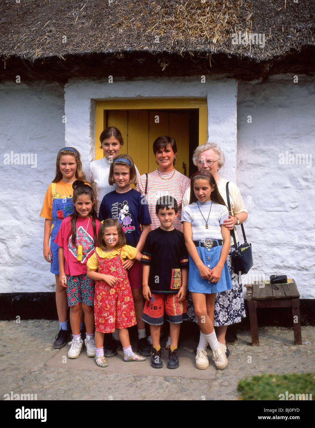 Gruppo di famiglia al di fuori di casa colonica, Ulster Folk & Transport Museum, County Down, Irlanda del Nord, Regno Unito Foto Stock