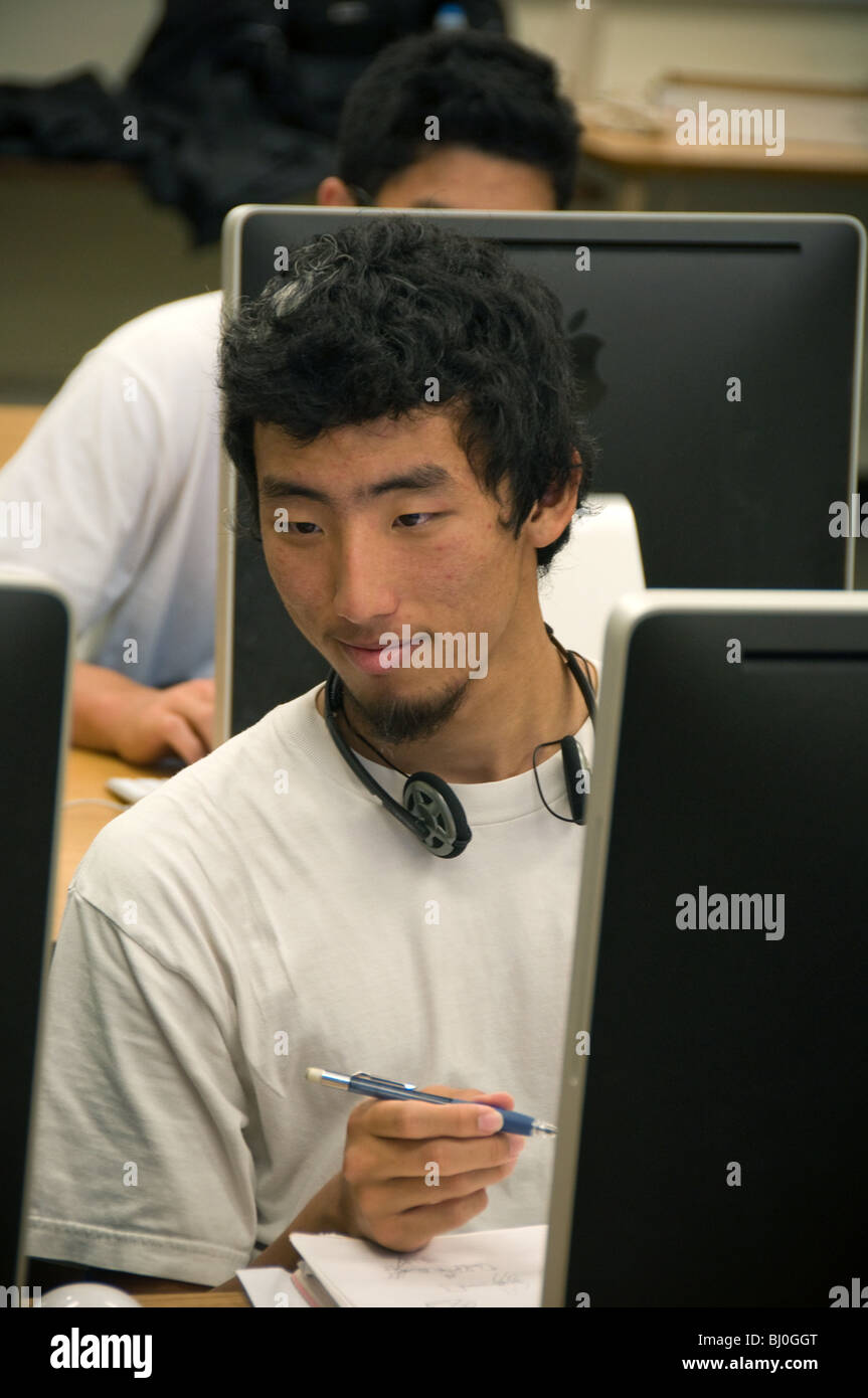 Il coreano maschio di alta scuola studente lavora su un computer Mac in fotografia digitale di classe. Foto Stock