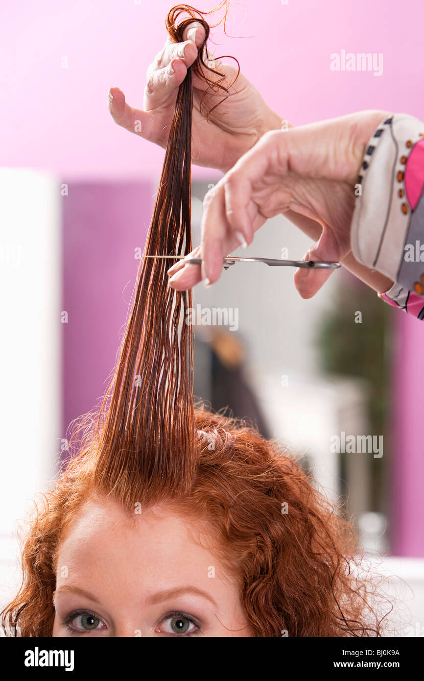 Dai capelli rossi donna ottenendo il suo taglio di capelli a salon Foto Stock