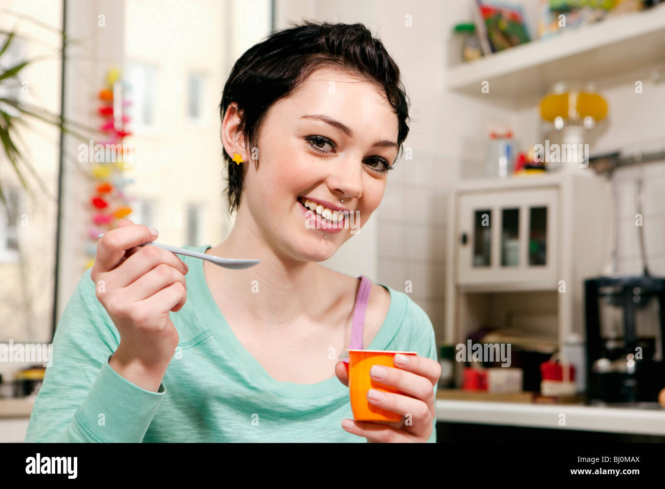 Ritratto di ragazza adolescente mangiare yogurt Foto Stock