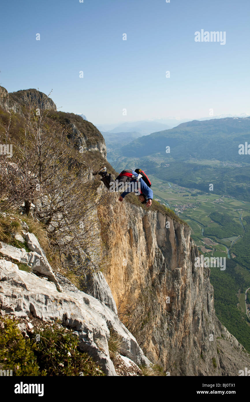 BASE jump da una scogliera. La ultimate kick per fare un salto in oggetto con front flip giù nella profonda valle. Foto Stock