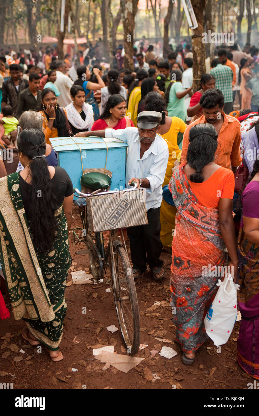 India Kerala, Kanjiramattom Kodikuthu festival musulmano, fornitore spingendo laden bicicletta attraverso la folla Foto Stock