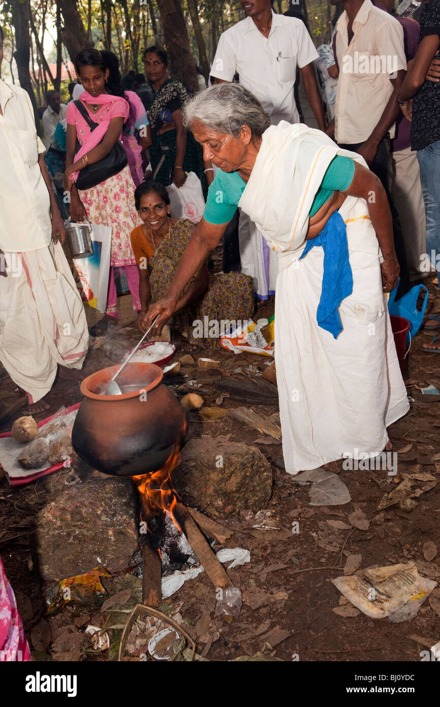 India Kerala, Kanjiramattom Kodikuthu festival musulmano, donna pongal cottura in pentola di creta oltre il fuoco di legno aperto Foto Stock