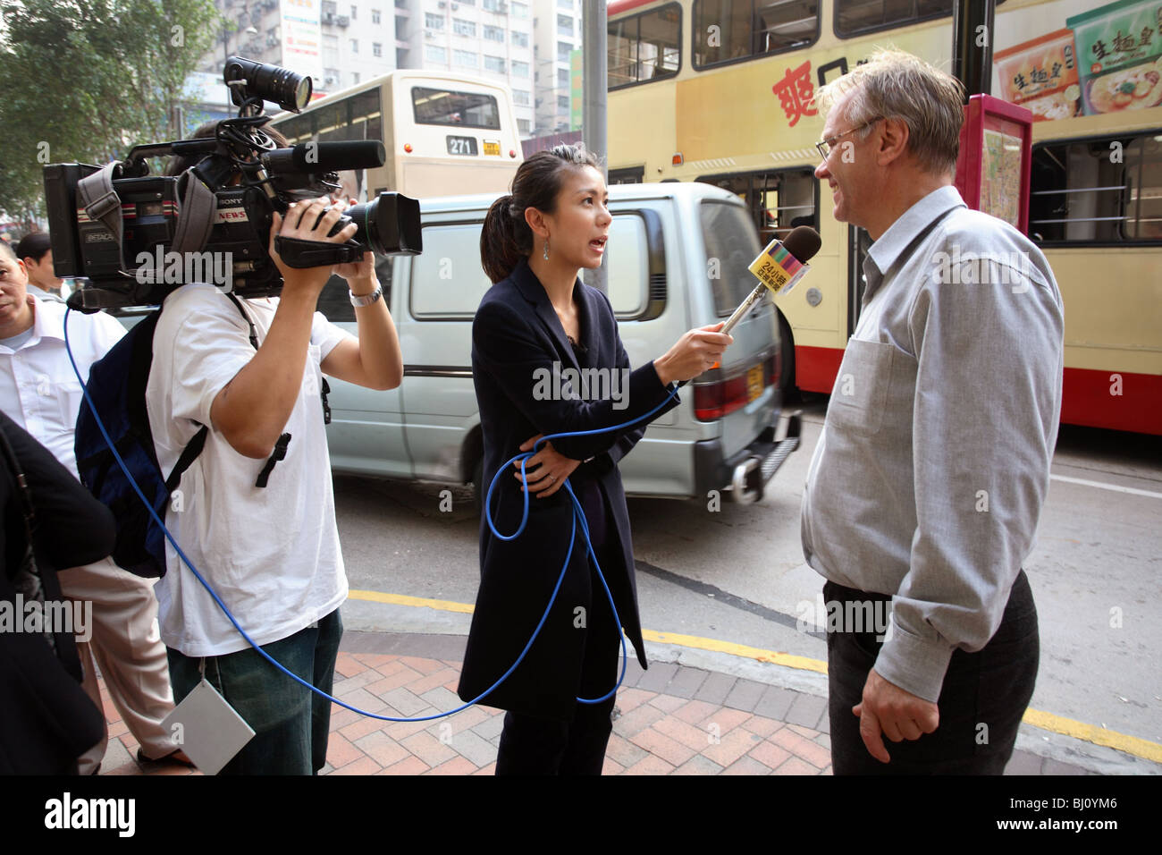 L uomo dando intervista su una strada, Hong Kong, Cina Foto Stock