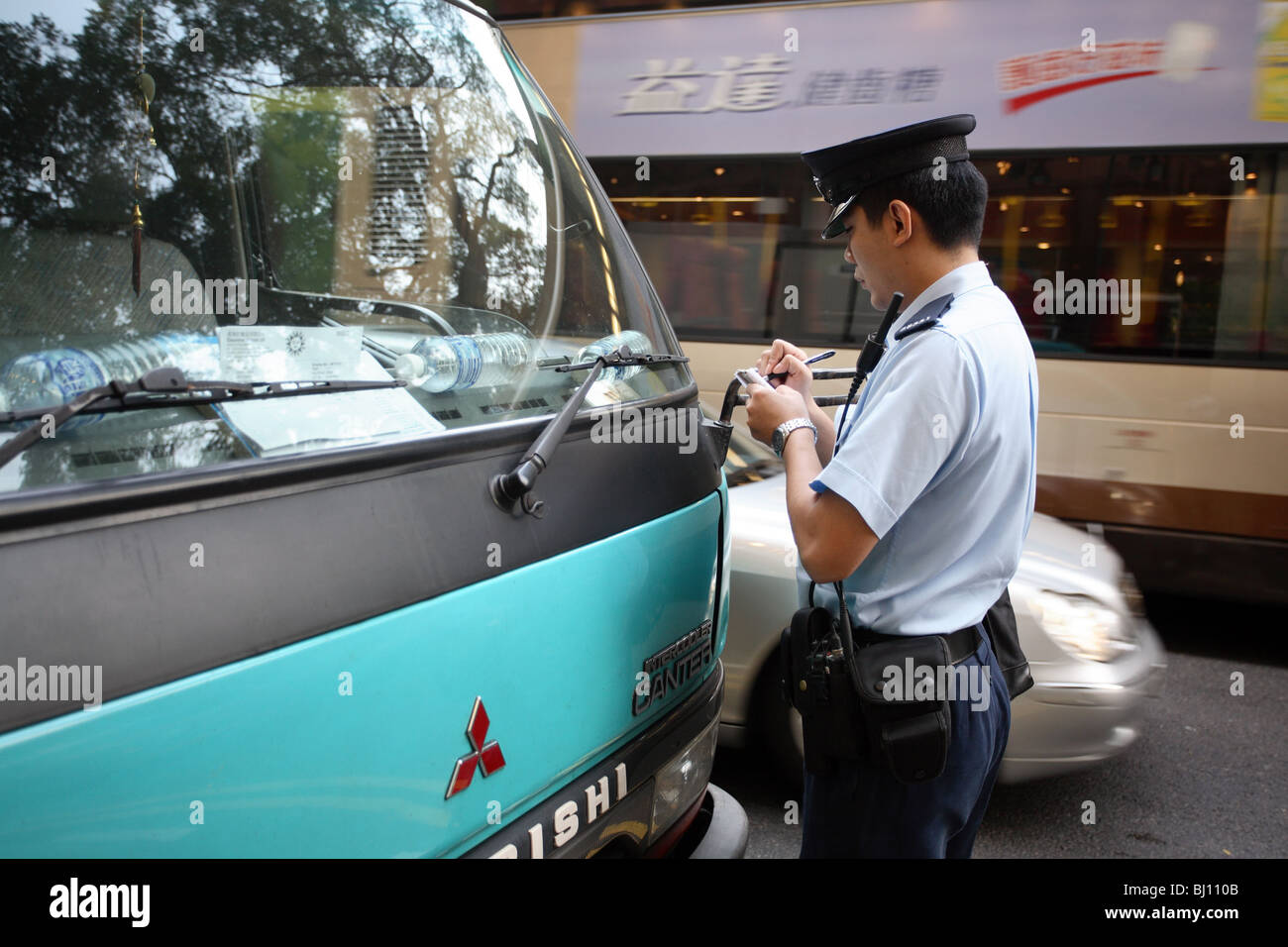 Poliziotto che rilascia un biglietto, Hong Kong, Cina Foto Stock