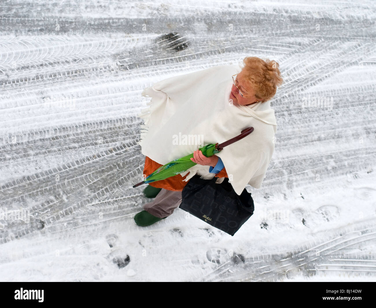 Donna con ombrello camminando sulla coperta di neve su strada - Francia. Foto Stock