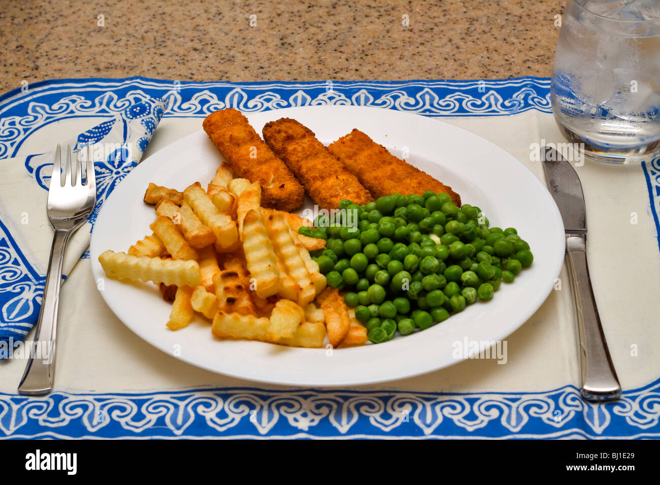 Un pasto leggero di bastoncini di pesce, patatine e piselli Foto Stock