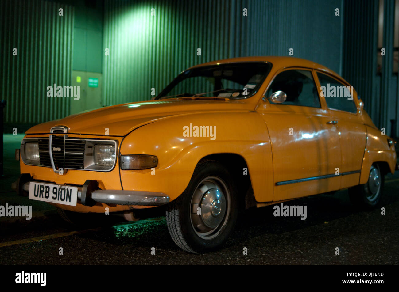 Orange Saab 96 auto, parcheggiato di notte Foto Stock