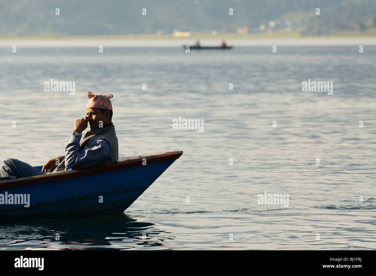 Uomo seduto in una canoa sul lago Pewha in Pokhara, Nepal Lunedì 26 Ottobre, 2009. Foto Stock