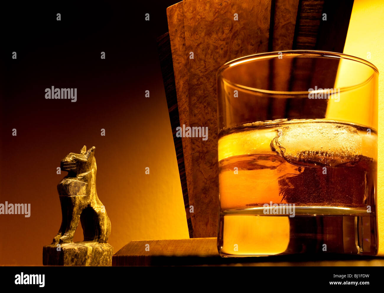 Immagine di caldo di art deco lampada ed ornamento con un bicchiere di whiskey in primo piano per sostenere il concetto di lusso e relax. Foto Stock