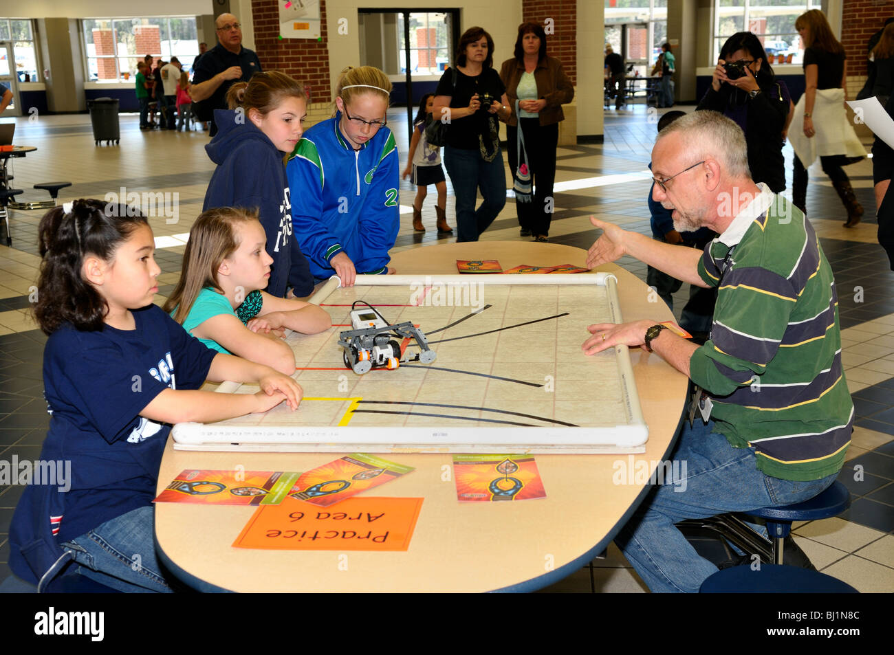 Coaching genitori bambini sulla costruzione di un robot Lego. Foto Stock