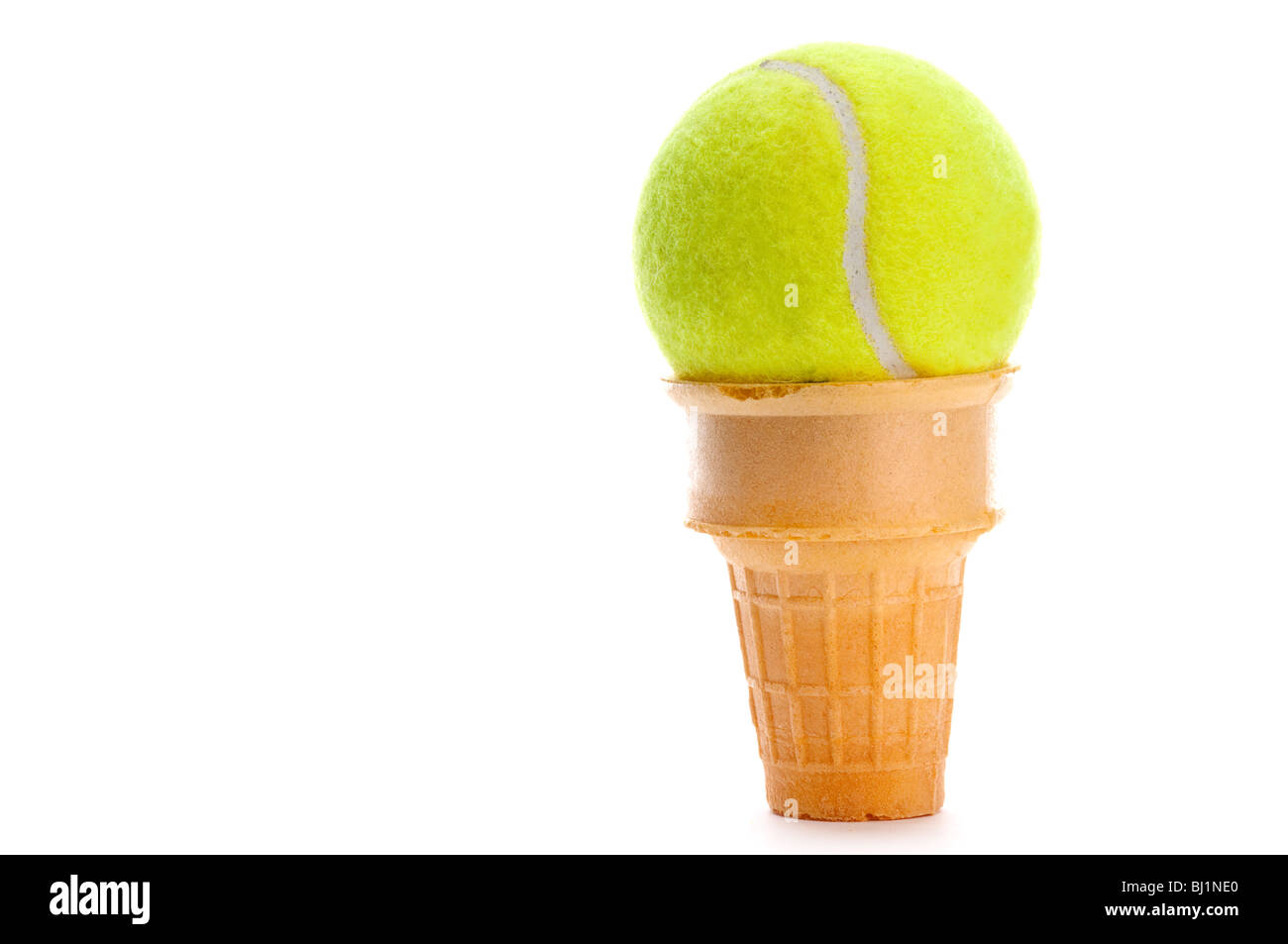 Un giallo palla da tennis in un cono gelato Foto Stock