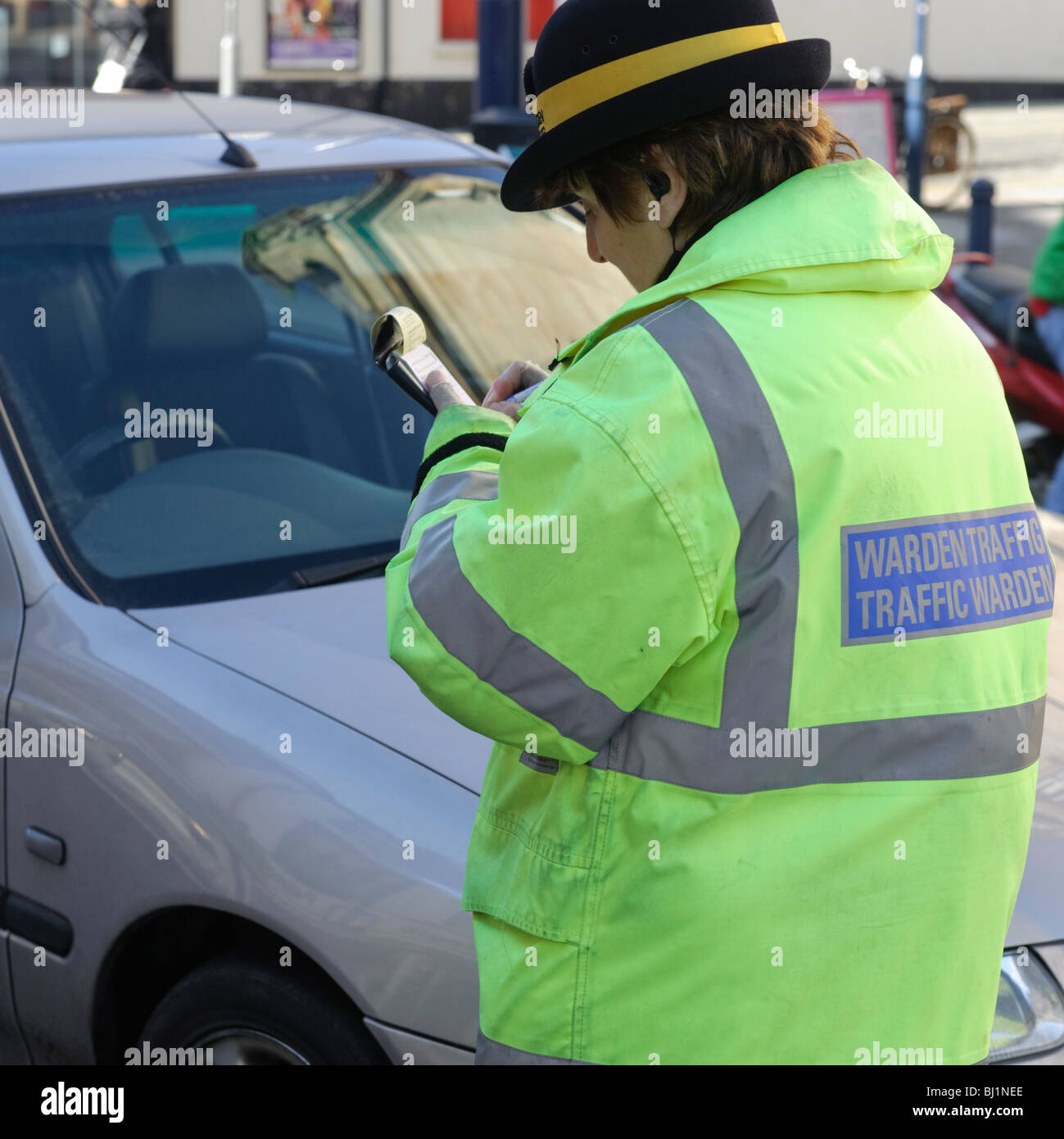 Una femmina di vigile di scrittura o di emissione di un biglietto di parcheggio, Aberystwyth Wales UK Foto Stock