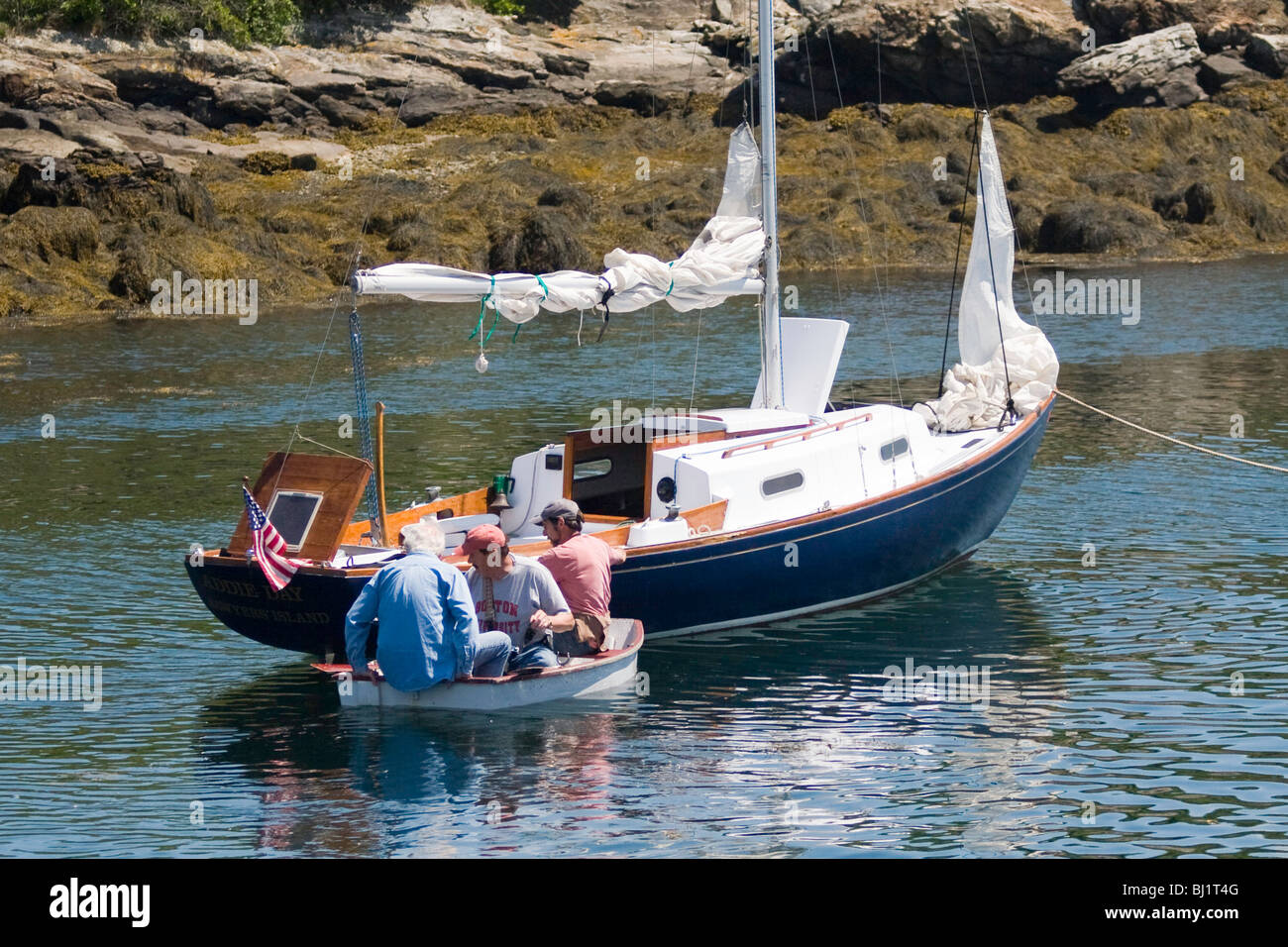 Isola di terra i visitatori a terra e tornare alla loro propria barca con l'aiuto della cortesia dinghy a Damariscove Isola, Maine Foto Stock