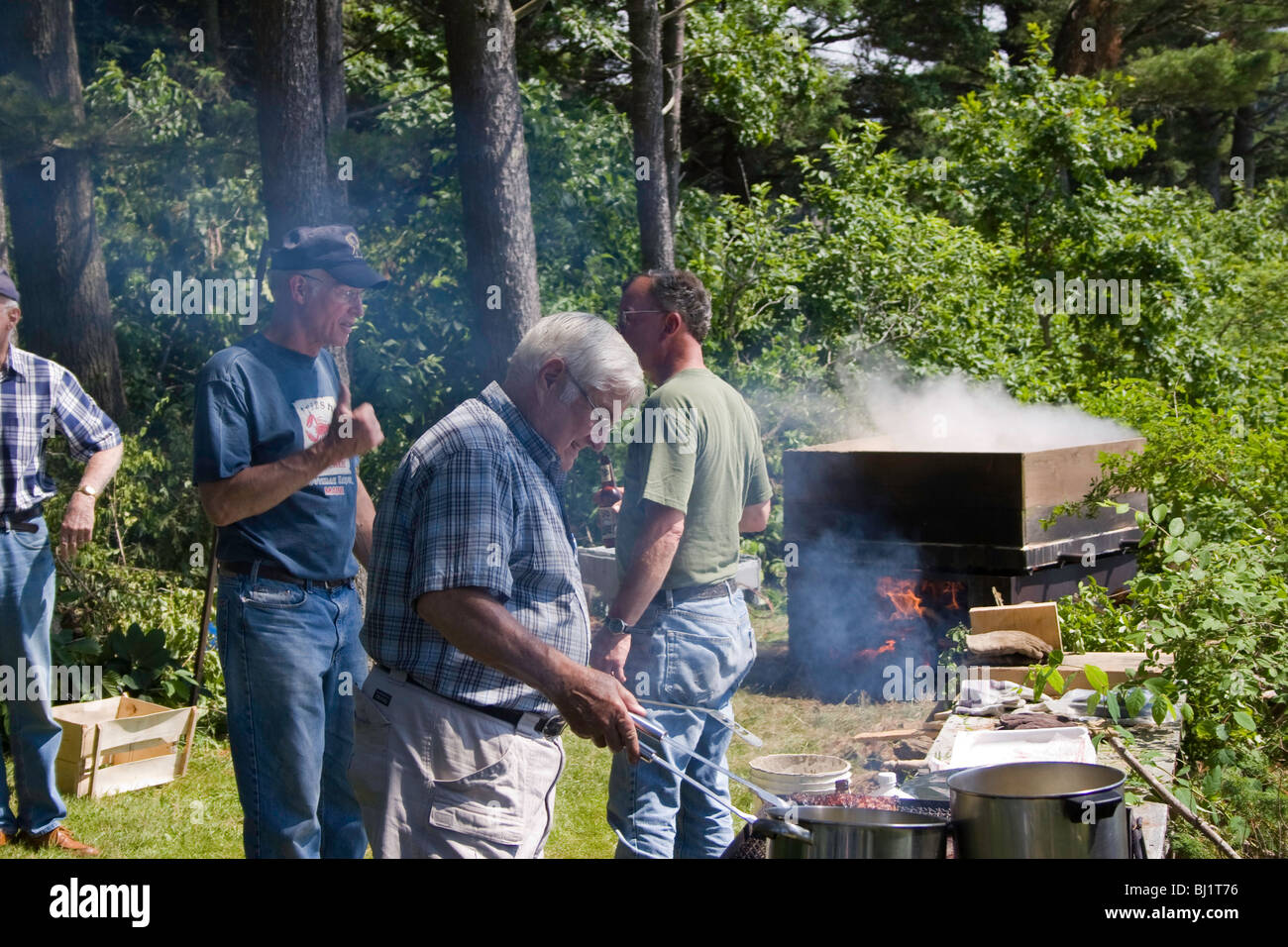 I cuochi preparare bistecche, la pannocchia e aragoste per un estate sociale Segatori Isola, Maine Foto Stock