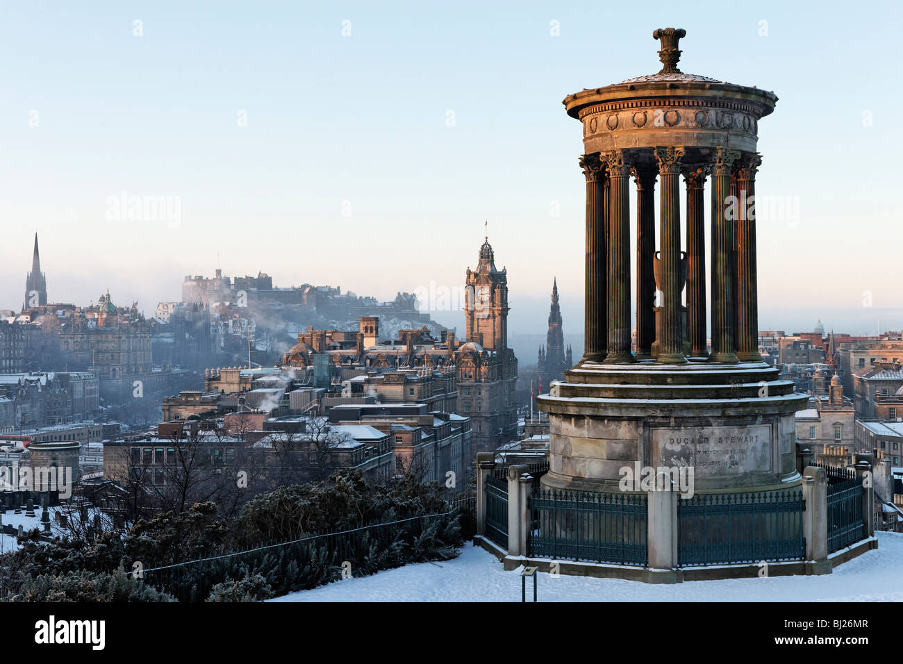 Il Dugald Stewart monumento su Calton Hill con vista dello skyline della città tra cui il castello di Edimburgo, Scozia, Regno Unito. Foto Stock