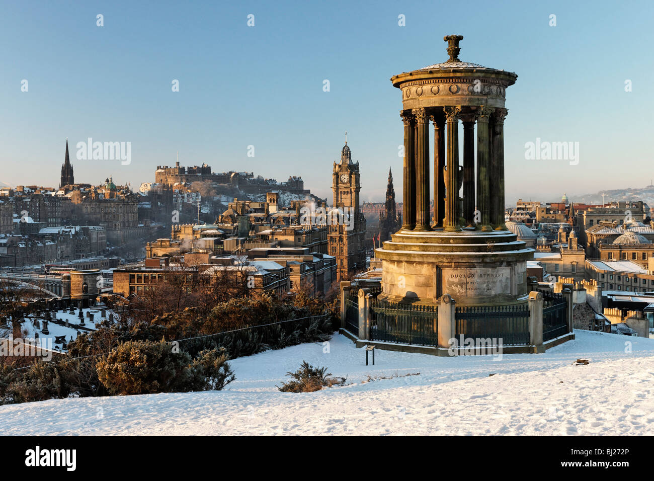 Il Dugald Stewart monumento su Calton Hill con vista dello skyline della città tra cui il castello di Edimburgo, Scozia, Regno Unito. Foto Stock