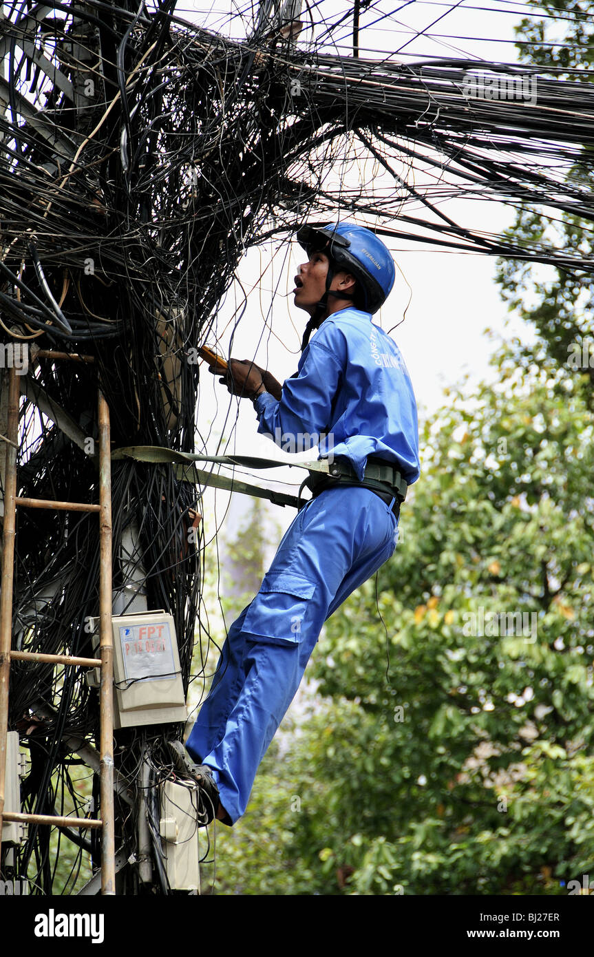 Città lavoratore fino un polo Controllo di cavi in Ho Chi Minh City, Vietnam Foto Stock