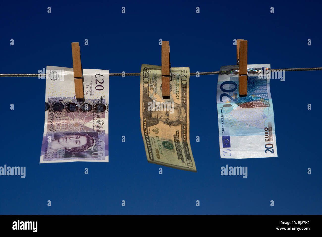 Venti libbre di dollari banconote in euro appeso su una linea di lavaggio con cielo blu Foto Stock