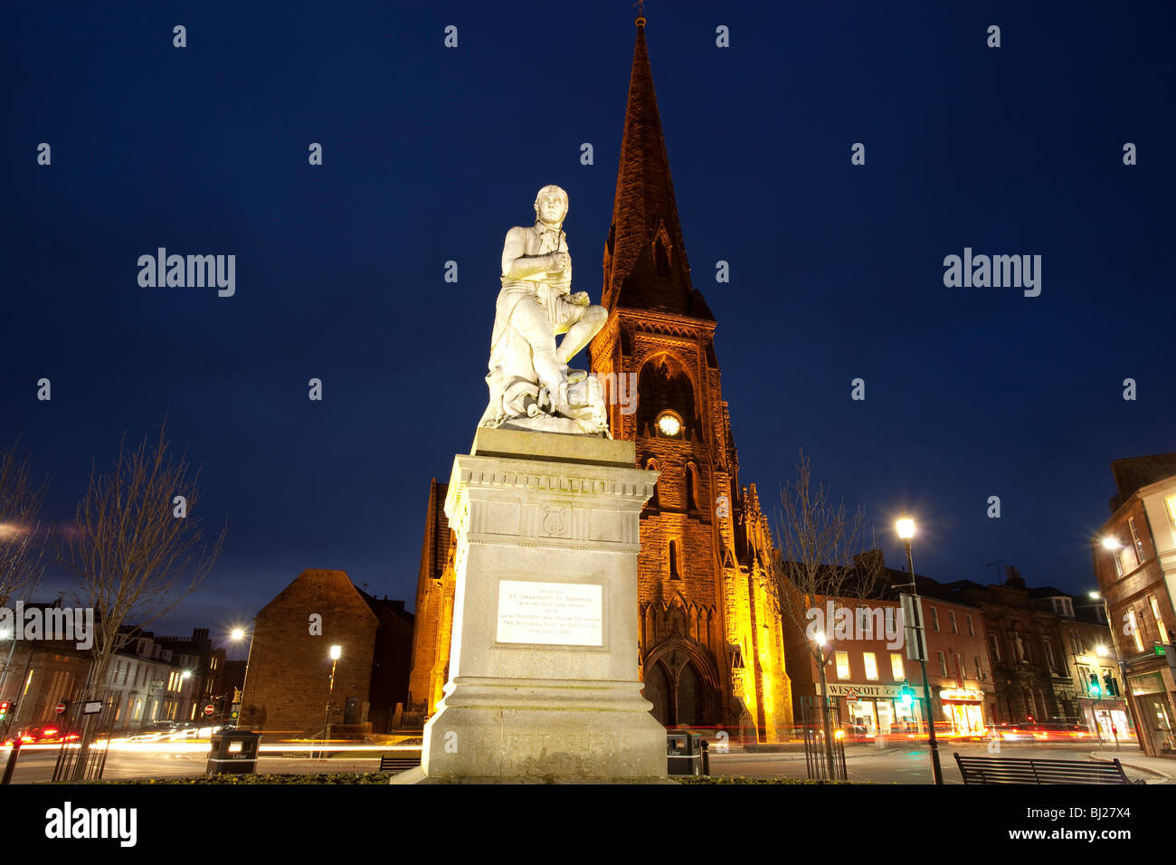 Il poeta Robert Burns statua in Dumfries town center con Greyfriars Chiesa dietro di notte Scotland Regno Unito Foto Stock