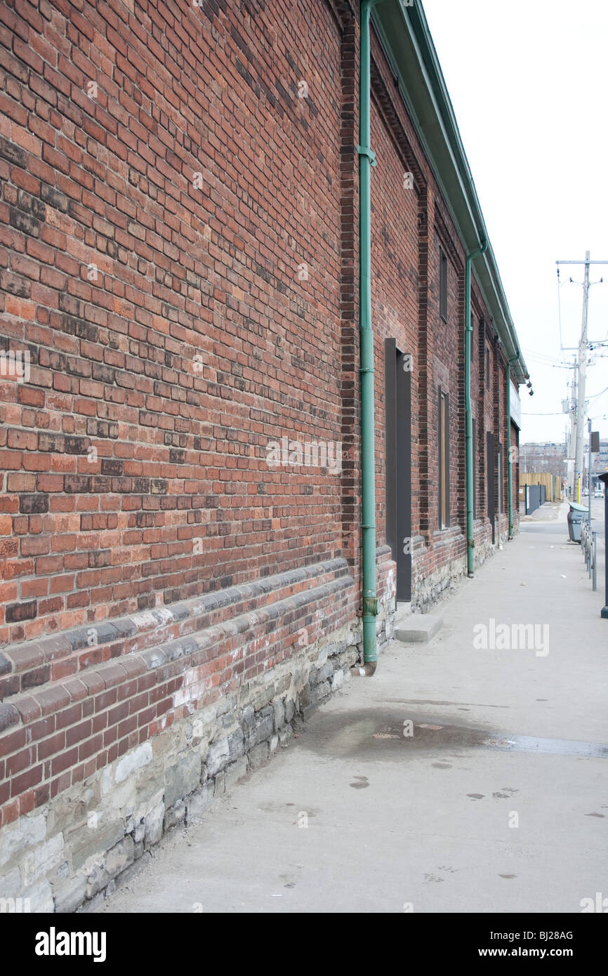 Red muro di mattoni e una strada Foto Stock