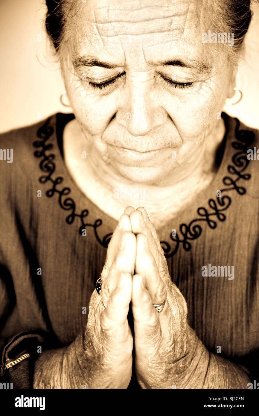 Religiosa cristiana donna senior in preghiera a Dio Foto Stock