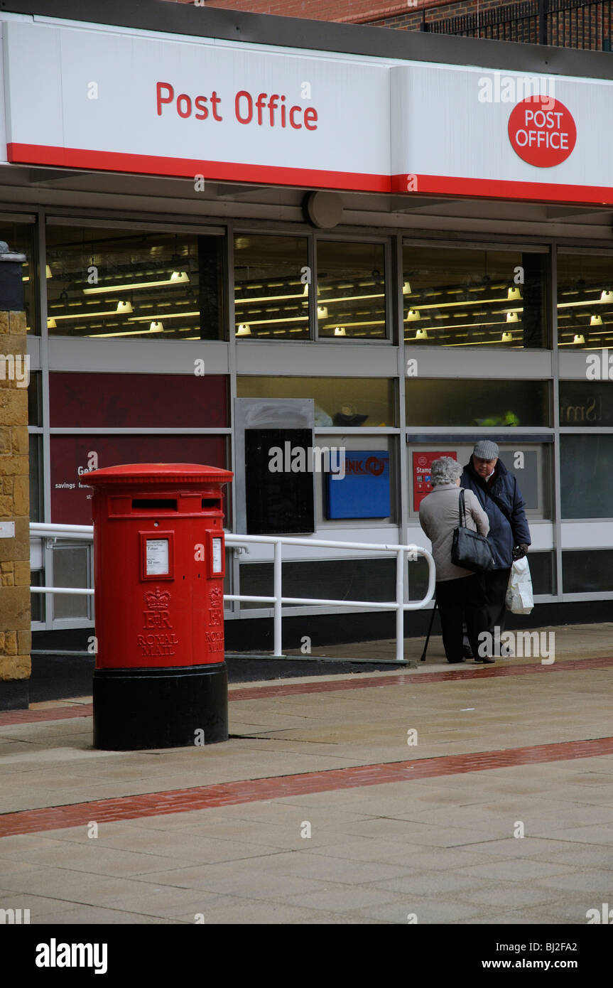 Ufficio postale e una coppia di anziani avente una chat al di fuori di questo ramo di Solihull situato nelle Midlands England Regno Unito Foto Stock