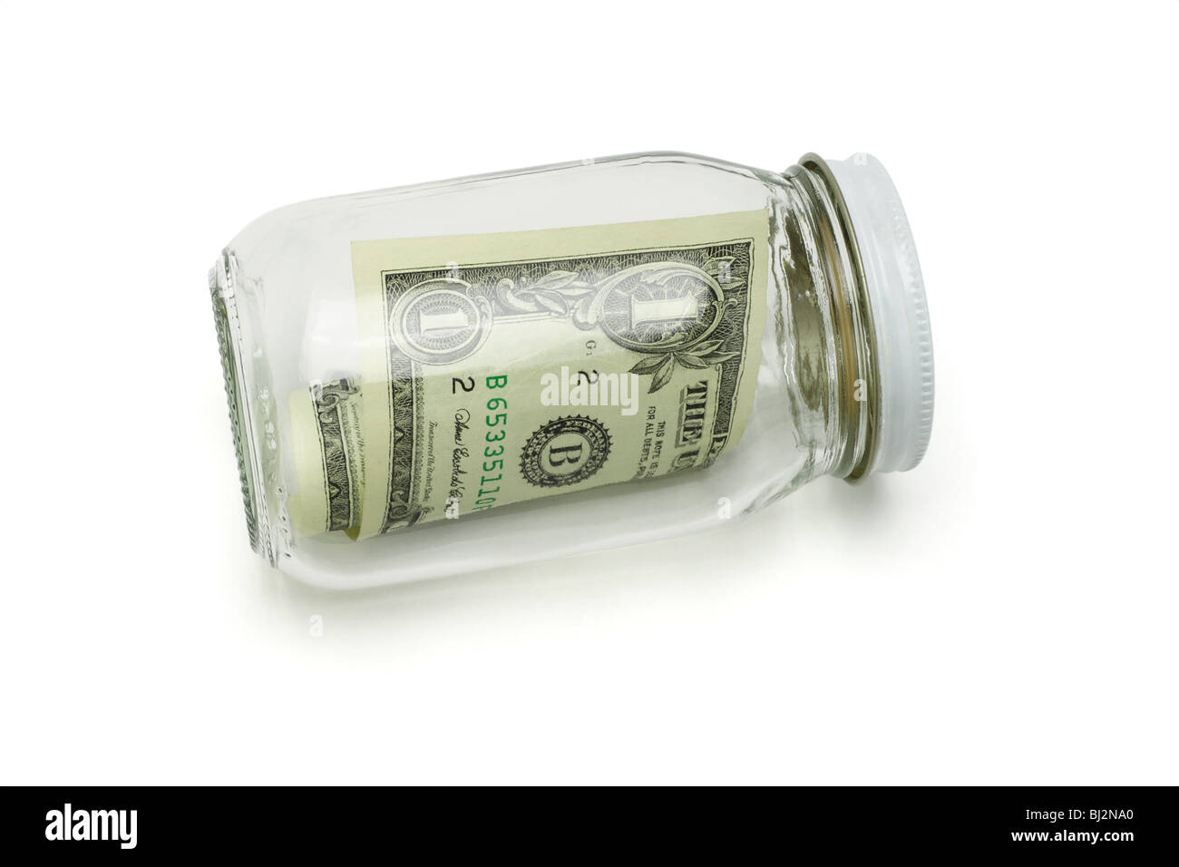 Un US dollar nota in un vasetto di vetro su sfondo bianco Foto Stock