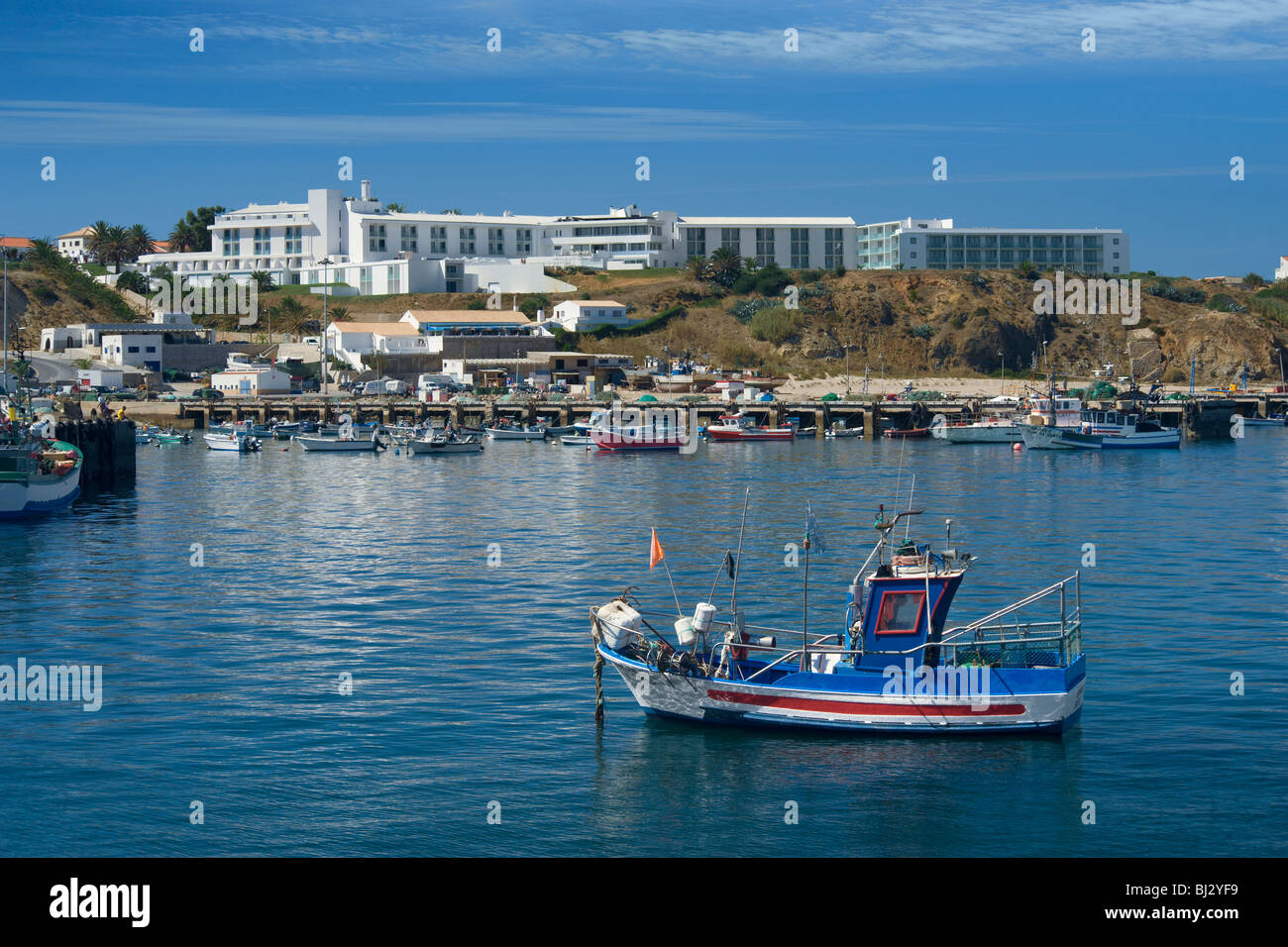 Il Portogallo, Algarve, Sagres, il porto. Una barca da pesca con la Memmo Baleeira Hotel dietro Foto Stock