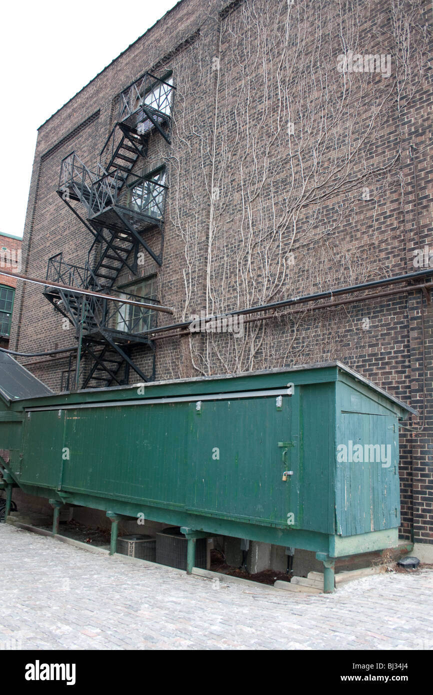 La parete laterale di una vecchia fabbrica con scale al di fuori Foto Stock