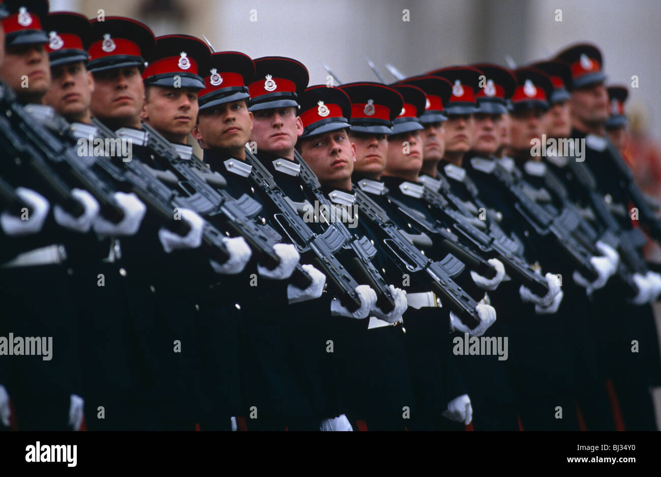 Passando dalla sfilata di diciassette allievi ufficiali marciando in pieno uniforme del vestito con i loro fucili sulle spalle a Sandhurst. Foto Stock