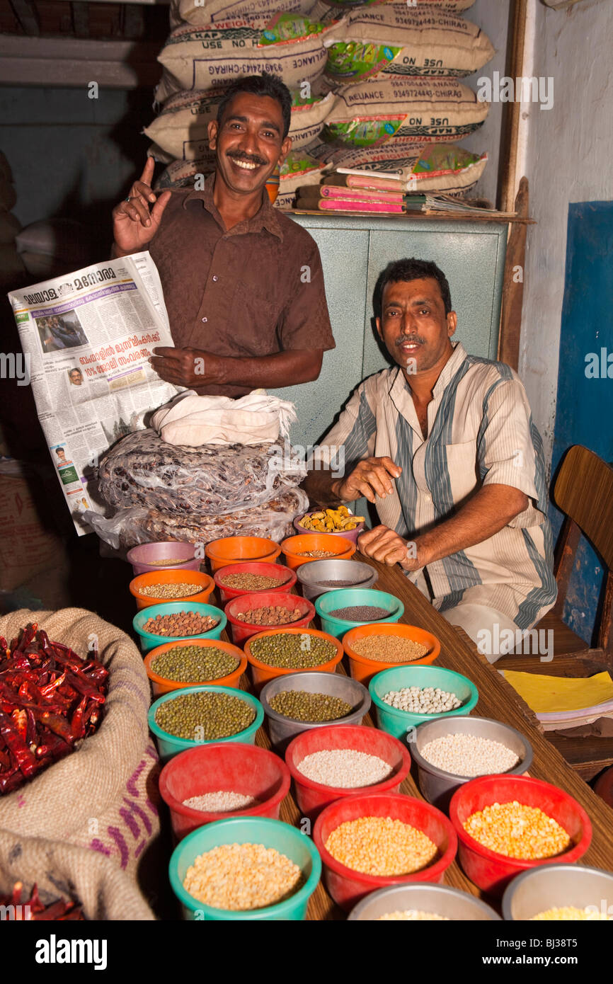 India Kerala, Calicut, Kozhikode, Halwa Bazaar, uomini che mostra le piastre di diverse secche campioni di impulso in grossista Foto Stock