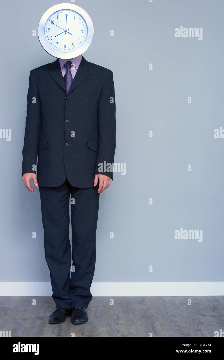 Uomo in un vestito con una testa di orologio Foto Stock
